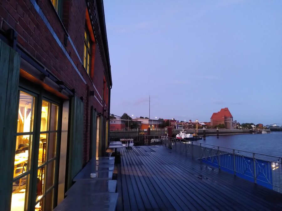 Von der Terrasse geht der Blick über die Elbe auf den alten Ölmühlenspeicher und den Hafen.